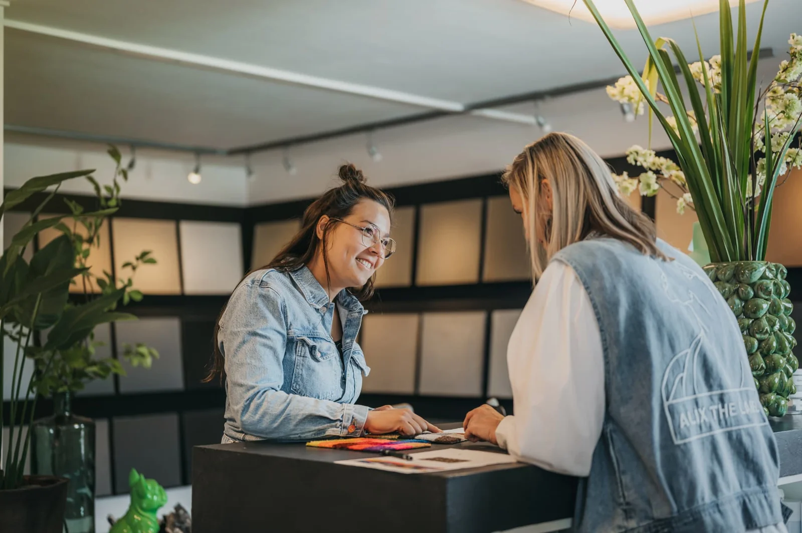 Adviesgesprek aan de balie in de showroom met stalen op tafel